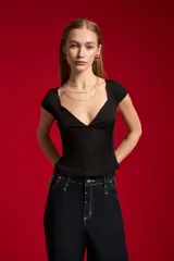 Top negro de manga corta con acabado de lúrex, cuello en V y diseño ajustado al cuerpo.