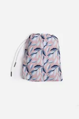 Short de baño celeste con estampado de hojas pequeñas en tonos verdes y blancos. Cuenta con cintura elástica con cordón ajustable, bolsillos laterales y un parche circular con logo en la parte inferior.