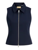 Chaleco ligero color azul marino con cuello camisero y cierre frontal de cremallera plateada. Diseño totalmente forrado y confeccionado en tejido plano.