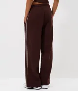 Pantalón de buzo de corte recto, color marrón, con cintura elástica y franjas laterales en contraste. Confeccionado en tejido de algodón y poliéster con interior de felpa.