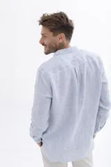 Camisa celeste a rayas verticales blancas, de manga larga y corte clásico.