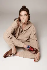 Zapatillas bajas de cuero color beige con detalles en marrón y azul. Cordones blancos y suela de goma color caramelo.