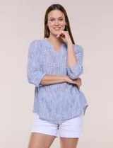 Blusa de silueta relajada con textura tramada y estampado a rayas. Presenta cuello mao con abertura en V, mangas tres cuartos con dobladillo ancho y detalle de pequeña abertura lateral en el puño, y espalda lisa con ruedo ligeramente curvado.