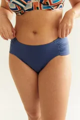 Bombacha de bikini tiro alto color azul marino, con frunce en los costados. Confeccionada con tela que contiene fibra LYCRA® XTRA LIFE™.