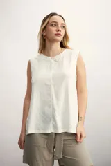 Blusa color blanco hueso, sin mangas, con cuello redondo y corte recto.