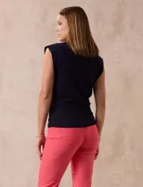 Buzo tejido en hilado fino color beige, con escote en V y sin mangas.