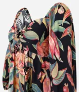 Vestido midi de corte evasé con estampado de follaje tropical sobre fondo negro. Presenta escote corazón, mangas abullonadas y un diseño fluido confeccionado en viscosa.