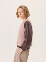 Chaleco de punto con textura calada en color rosado, de corte recto y cuello redondo.