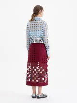 Pollera midi cruzada confeccionada en guipur color bordó con espejos circulares bordados. Presenta una abertura lateral y forrería interna al tono.