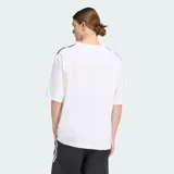 Remera oversized Adidas Adicolor de color blanco, de corte holgado, con cuello redondo, mangas cortas con las icónicas tres tiras negras y el logo Trefoil bordado en el pecho.
