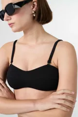 Top de bikini bandeau negro con textura acanalada, tirantes ajustables y removibles.