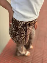 Cinto marrón con textura símil cuero, argollas plateadas y lazos de ajuste.