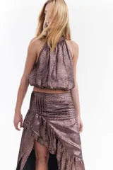Top metalizado color cobre, con cuello halter y diseño balloon con caída fluida.