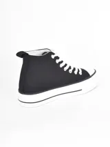 Zapatilla de caña alta con plataforma, confeccionada en lona negra con cordones y puntera de goma blanca.