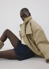 Short de denim azul oscuro con diseño de cinco bolsillos, tiro medio y cierre frontal de cremallera y botón.