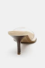 Sandalia tipo mule color beige con tira de vinilo transparente y tacón fino.