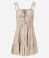 Vestido corto de silueta evasé color celeste, con escote recto y detalle de lazo en el centro. Posee breteles medianos, cintura elástica fruncida y falda con volados escalonados.