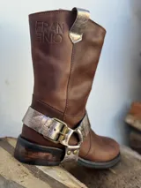 Bota de cuero marrón con estribo desmontable plateado.