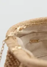 Bolso tipo clutch de fibra natural trenzada en color beige, con diseño frontal fruncido y nudo central, y cierre superior de aro a presión.