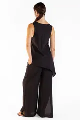 Top negro asimétrico con textura natural, cuello redondo y diseño sin mangas de caída ligera.