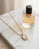 Collar de acero con baño de oro, con cadena tipo serpiente y dije rectangular con cristal central engastado.