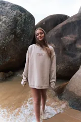 Buzo beige de corte holgado, tejido acanalado y cuello redondo. Estampado frontal con la frase "Glassy Waves Beach Life".