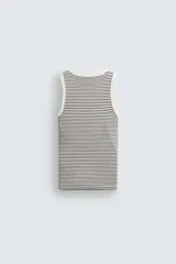 Camiseta sin mangas de corte regular, confeccionada en tejido de algodón con elasticidad. Presenta un diseño de rayas horizontales finas, cuello redondo y acabados en vivo doble.