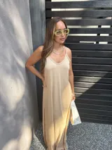 Vestido largo color beige, de viscosa, con tirantes finos, escote en V y aberturas laterales en la falda.