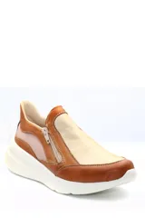 Zapatilla deportiva marrón de cuero liso con detalles en beige y plateado. Presenta cierre lateral y suela gruesa blanca.