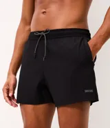 Bermuda de running Get Over para hombre, confeccionada en microfibra ligera de color gris claro. Presenta cintura elástica con cordón ajustable, bolsillos funcionales, dobladillo redondeado con aberturas laterales y pequeño parche con logo de la marca en la pierna izquierda.