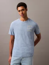 Remera celeste de manga corta con logo de Calvin Klein Jeans estampado en amarillo.