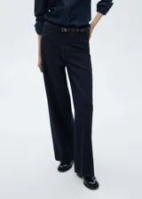 Pantalón de jean estilo wideleg color azul oscuro, con tiro medio, cuatro bolsillos y cinturón incorporado con hebilla metálica.