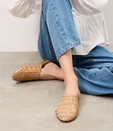 Chatita estilo mule de Satinato, color tostado, con parte superior en trama de rafia con diseño geométrico calado y punta levemente afinada.