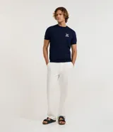 Remera azul marino de viscosa con cuello redondo y mangas cortas. Presenta un bordado con motivos marineros en el frente. Corte regular.
