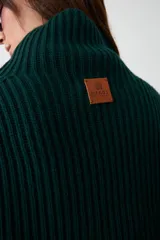 Capita de punto acanalado en color verde oscuro, con cuello alto y diseño corto que cubre hombros y pecho.