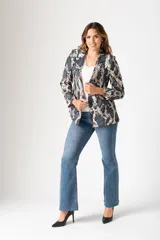 Blazer de poliéster con estampado animal print en tonos grises y beige. Tiene corte ajustado, cuello con solapa y cierre frontal con un botón negro.