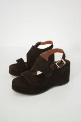 Sandalias de plataforma color marrón oscuro, con dos tiras anchas sobre el empeine y tobillo con hebilla.
