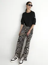 Pantalón de tul con estampado de cebra, corte palazzo y cintura alta con elástico.