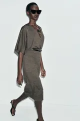 Vestido midi de escote en pico cruzado y manga corta. Presenta detalle de frunces en la cintura y un cinturón integrado con hebilla metálica a contraste.