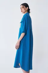 Vestido camisero azul con mangas cortas y bordado en el frente.