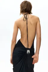 Top halter extralargo de punto elástico, color negro, con maxiescote drapeado, tiras finas para anudar al cuello y diseño asimétrico con fruncidos en los laterales.