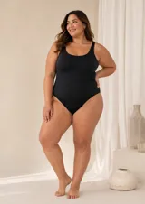 Malla enteriza clásica de color negro, con escote moderado, corte bajo el busto y espalda descubierta con tiras cruzadas.