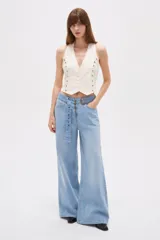 Pantalón jean celeste de tiro medio y corte ancho, con presillas, bolsillos delanteros y traseros, e incluye un cinturón largo del mismo material con hebilla metálica.