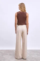 Musculosa tejida color marrón con detalle de nudo en la parte delantera.