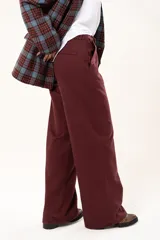 Pantalón de vestir color bordó, de corte recto y tiro alto, con bolsillos laterales y cierre frontal con botón.