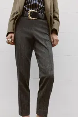 Pantalón de tiro alto con diseño de espiga, corte recto y nervio marcado en el frente. Incluye un cinturón ancho con hebilla metálica dorada y cierre lateral con cremallera oculta.