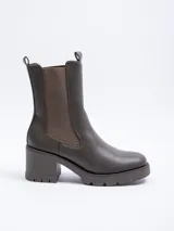 Bota tipo chelsea de caña alta confeccionada en cuero sintético, con paneles elásticos laterales, plataforma dentada y taco cuadrado.