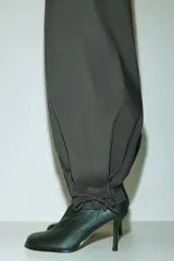 Pantalón de popelina de algodón negro, de corte ancho y silueta globo con cordón ajustable en los bajos y en la cintura elástica.