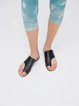 Sandalias chatas de cuero color crudo, con diseño geométrico y minimalista.