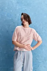 Blusa de manga corta color rosado con estampa orgánica de inspiración floral, cuello redondo y ajuste mediante lazo en el ruedo.